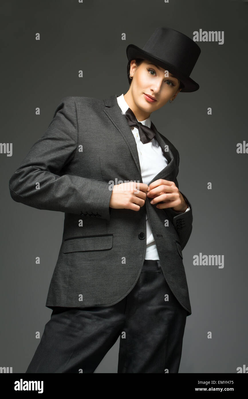 Young woman wearing man's suit posing over grey background. Retr Stock ...