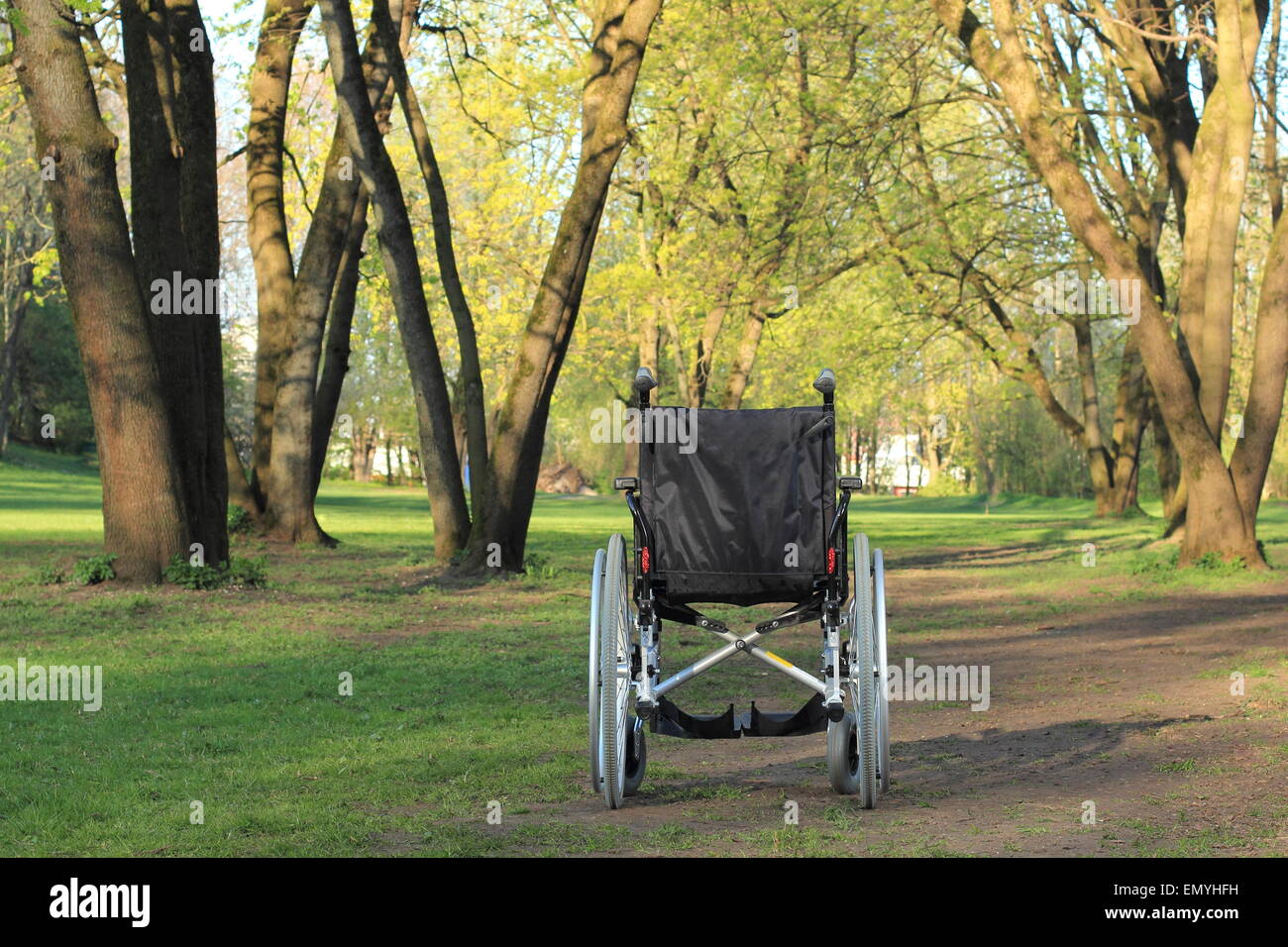 A Empty wheelchair standing in a park Stock Photo