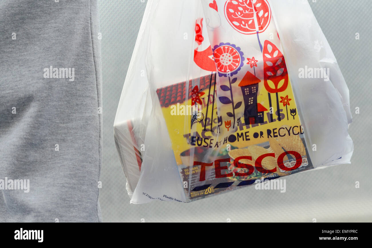 Person Holding a Tesco Carrier Bag Stock Photo