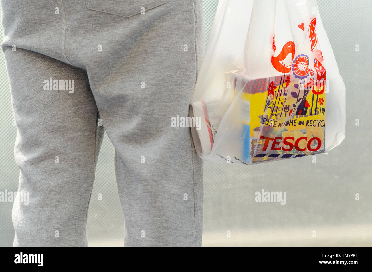 Person Holding a Tesco Carrier Bag Stock Photo