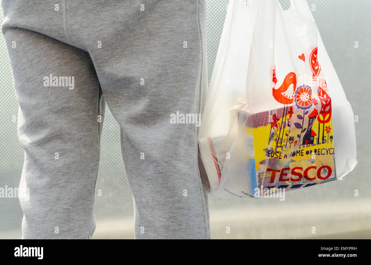 Person Holding a Tesco Carrier Bag Stock Photo