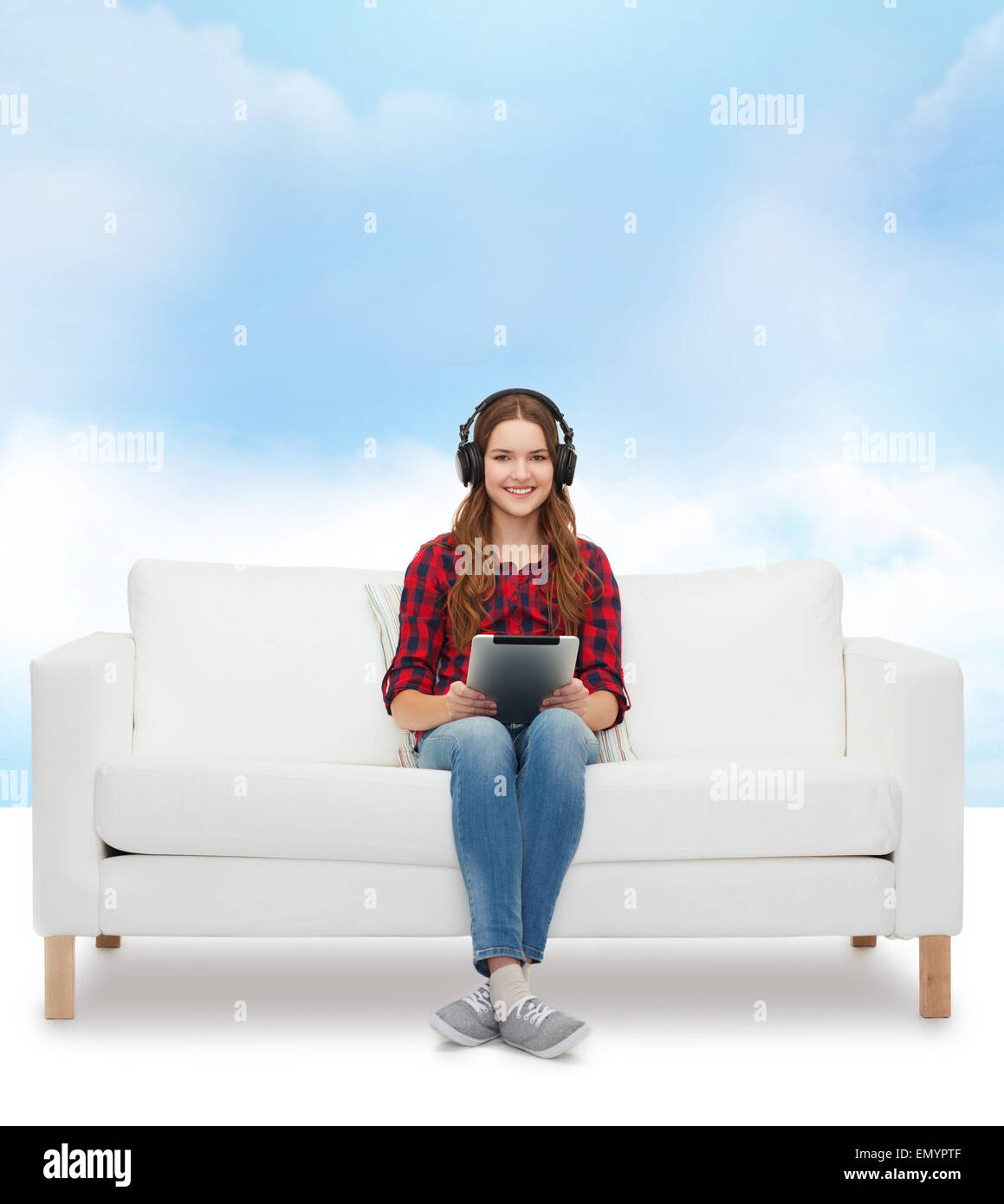 girl sitting on sofa with headphones and tablet pc Stock Photo - Alamy