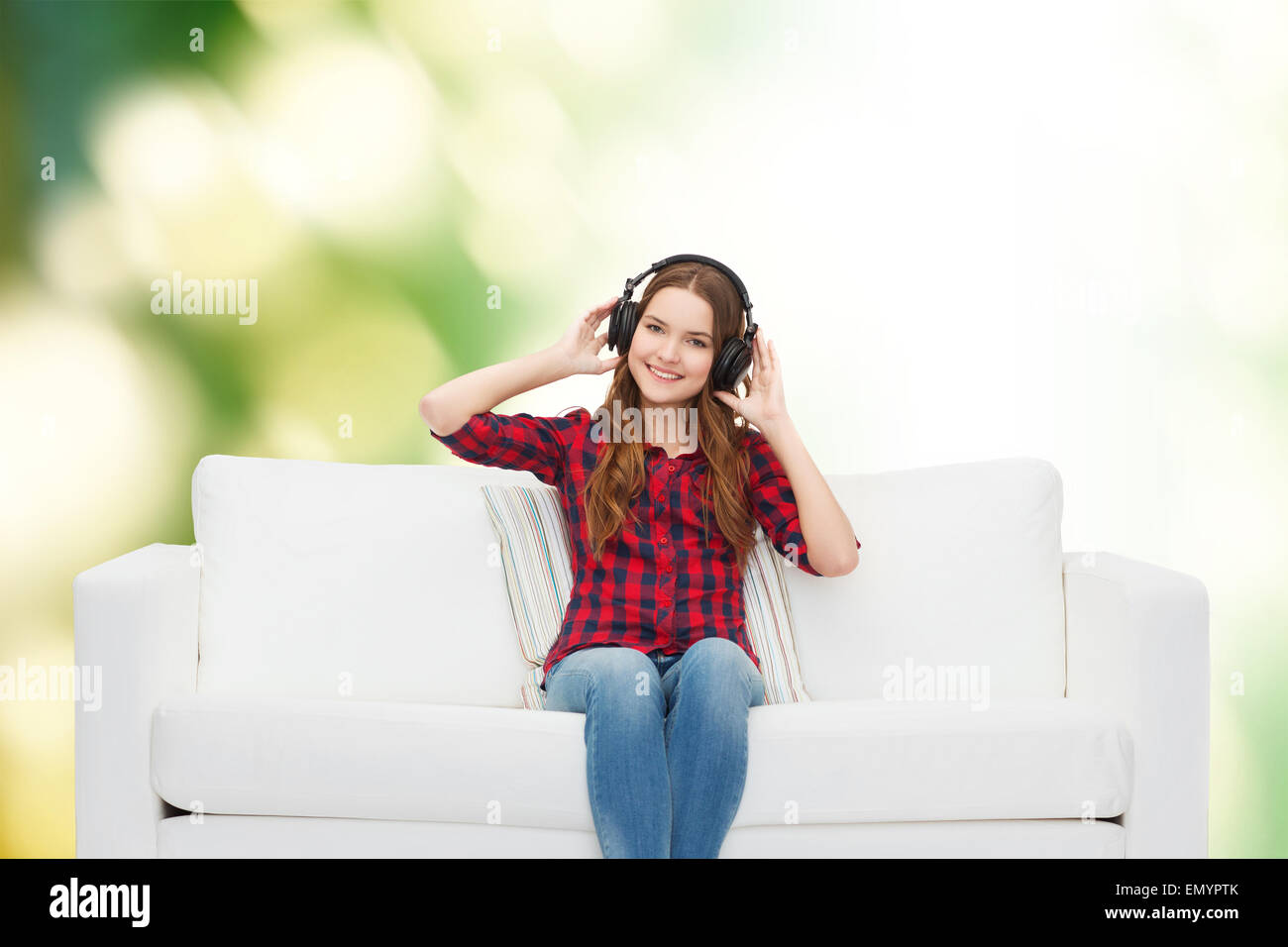 teenage girl sitting on sofa with headphones Stock Photo - Alamy