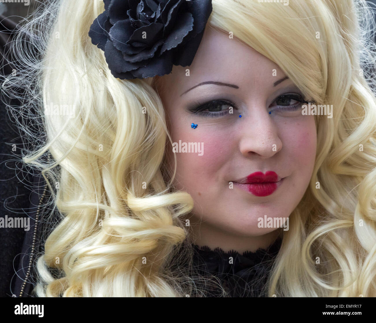 Female Goth wearing red lipstick and black rose at Whitby Goth weekend. Whitby. UK Stock Photo