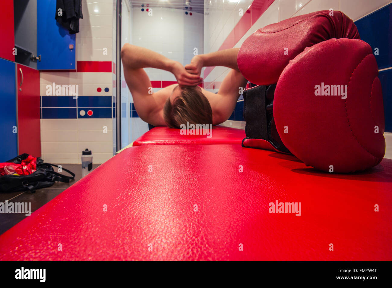 Tired man lying in the locker room after finishing training Stock Photo