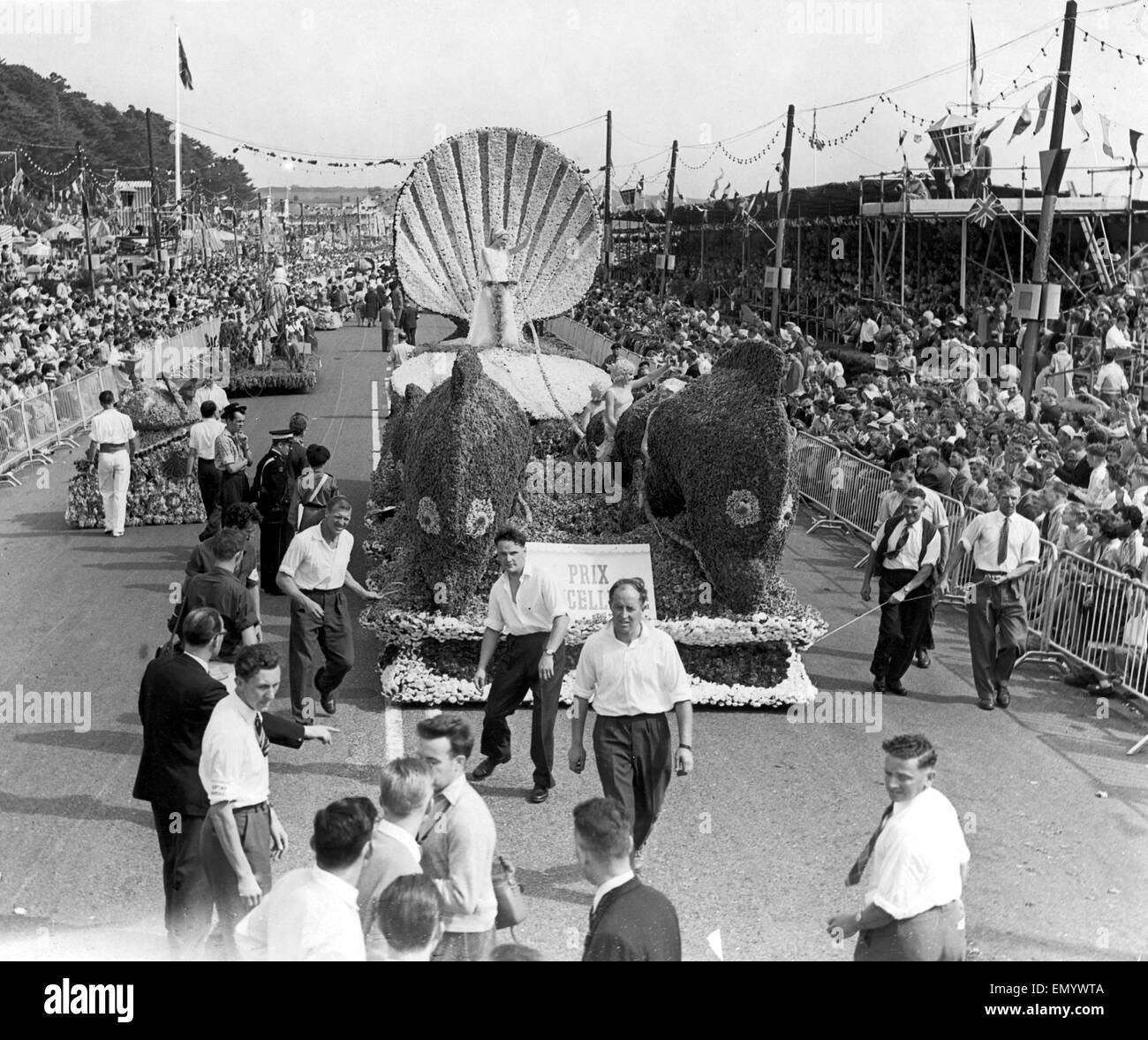 The annual Battle of Flowers carnival taking place on the island of Jersey in the Channel Islands. The procession moves along the street as crowds look on. Circa 1950. Stock Photo