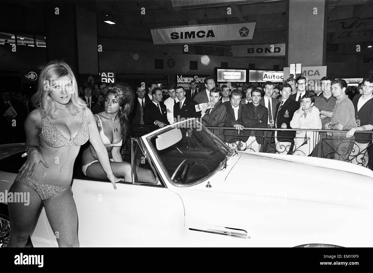Models drapped over cars at the London Motor Show 18th October 1966. Stock Photo