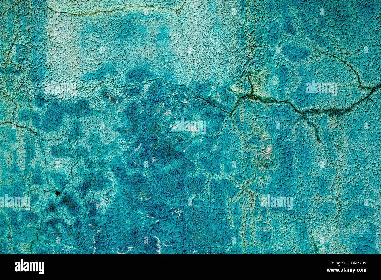 Blue painted wall with cracks and different hues of blue paint Stock Photo