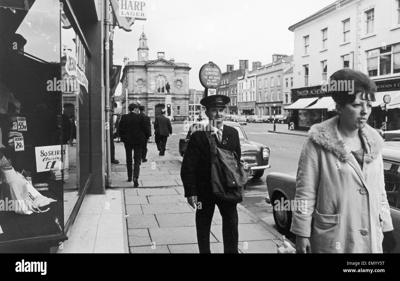 Postman seen here walking through the shopping area of Coleraine after delivering all his letters. Circa 1966 Stock Photo