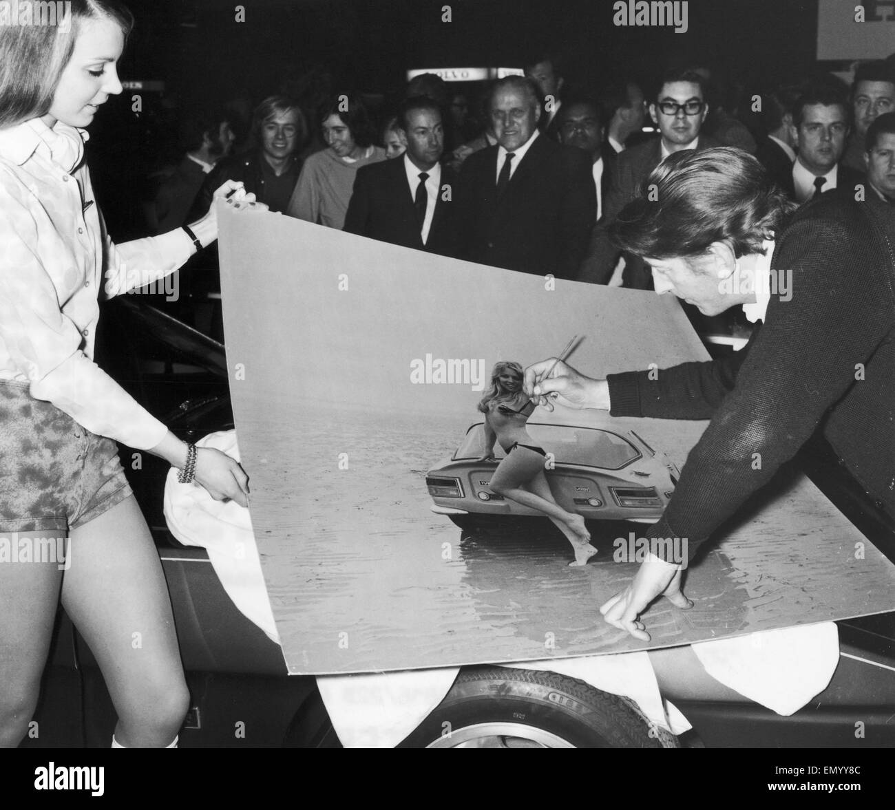 A hastily commissioned artist conceals the female form beneath an ink bikini on the TVR stand at the 1971 Motor Show, after the company was told that all picture must be made decent. 21st October 1971 Stock Photo