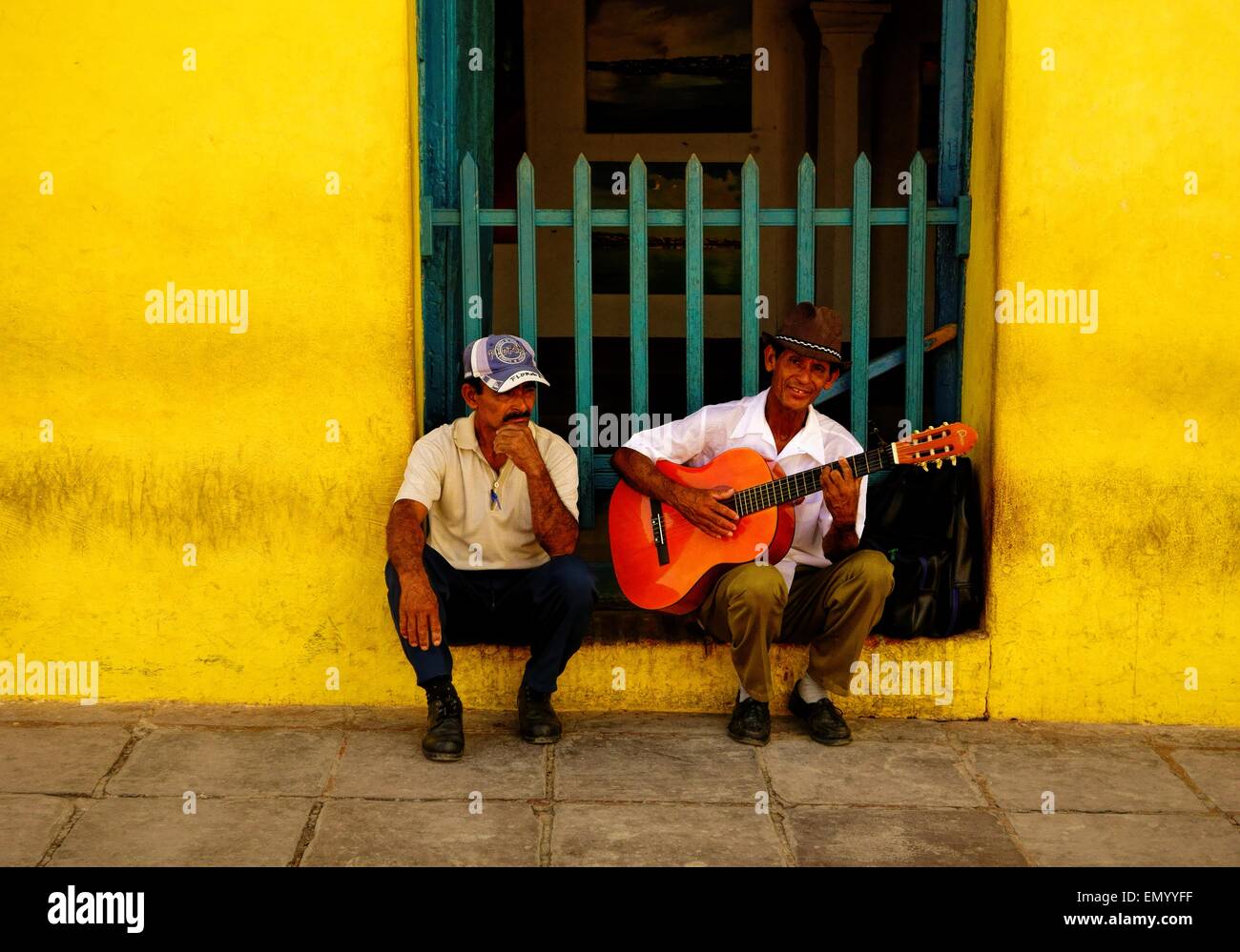 Busker and a man in the streets of Trinidad, Cuba on Christmas Eve 2013. Stock Photo