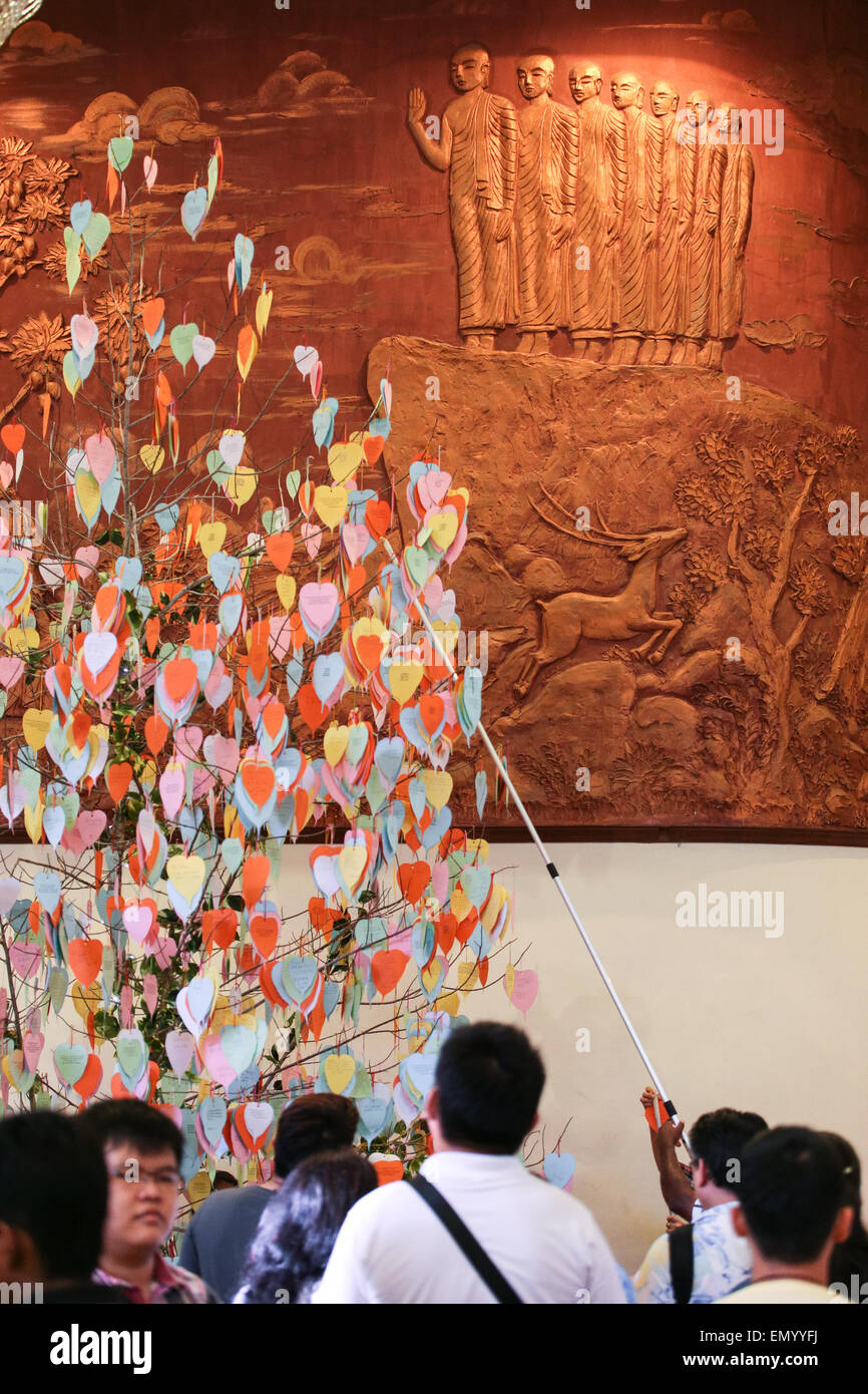 Visitors hanging their wishes card on a tree at Buddhist Maha Vihara Temple during Vesak day at Kuala Lumpur Malaysia. Stock Photo