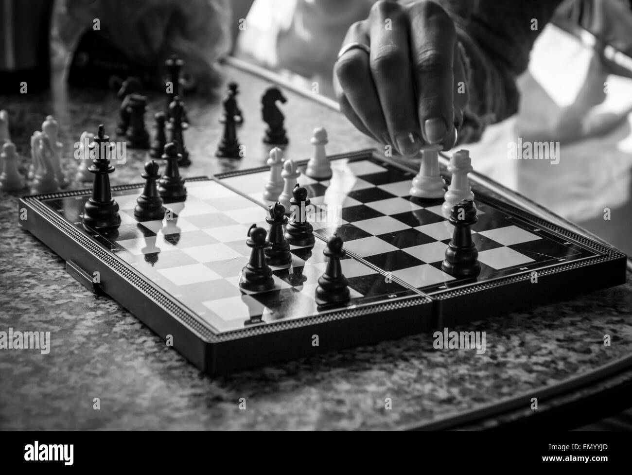 Female hand moving a white chess piece during the game of strategy Stock Photo