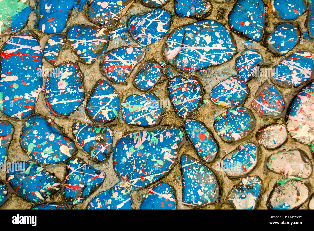 Stones covered in paint drops and drips creating a distinctive splatter pattern Stock Photo