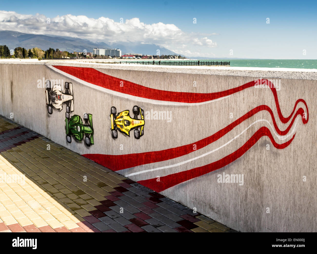 Three racing cars race on a hand painted mural on the sea coast Stock Photo