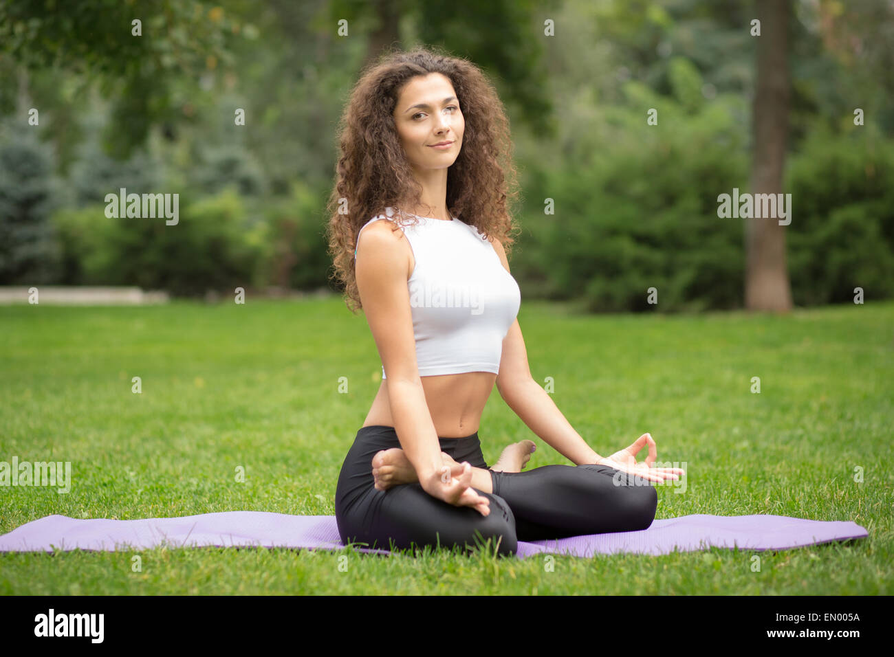 Pretty woman doing yoga meditation in the lotus position Stock Photo