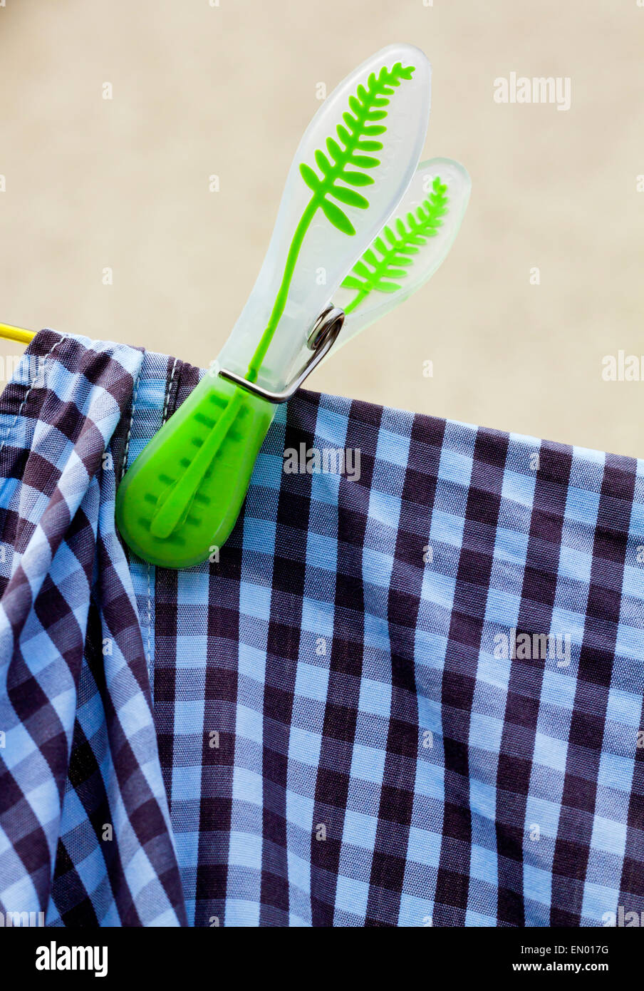 Plastic clothes peg on a washing line with shirt hanging out to dry Stock Photo