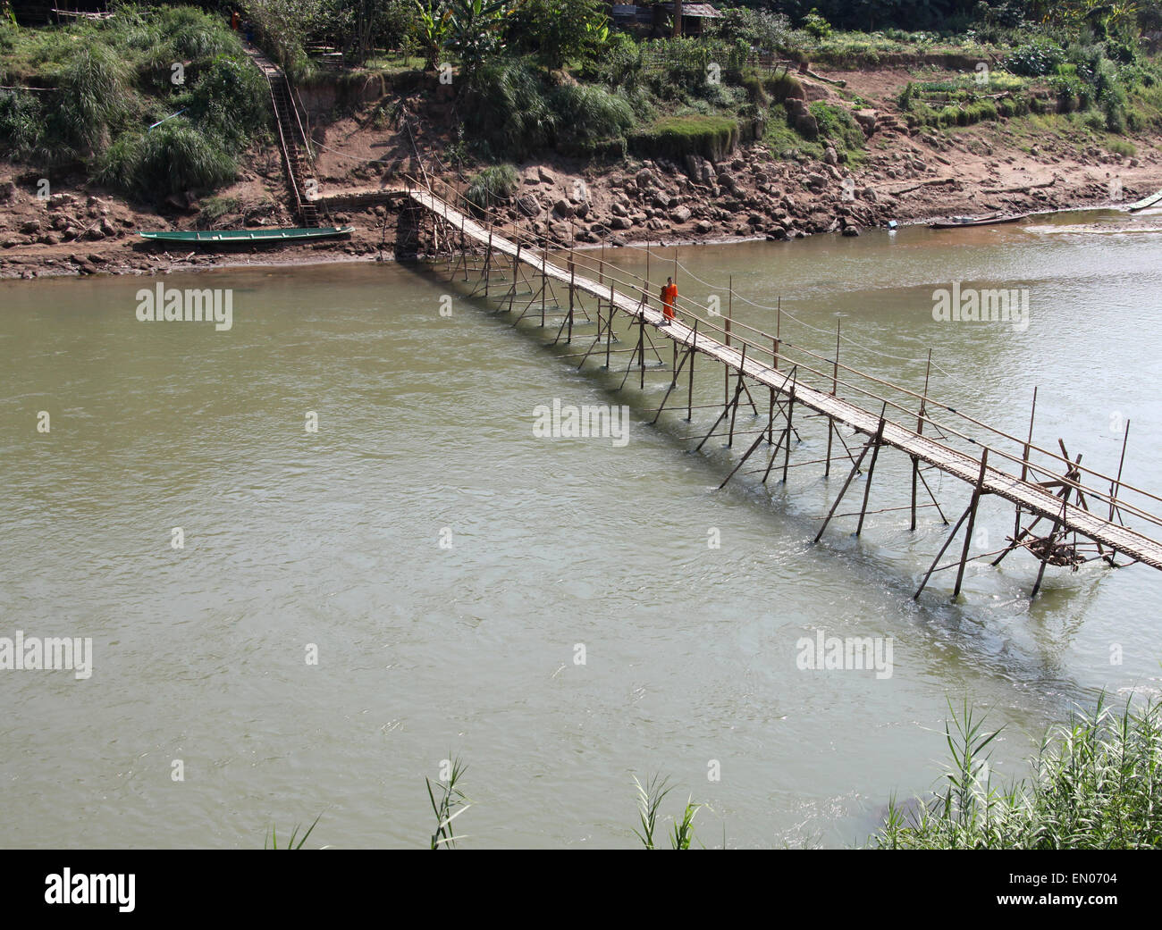 Monk walking across the bamboo bridge at Luang Prabang in Laos Stock Photo