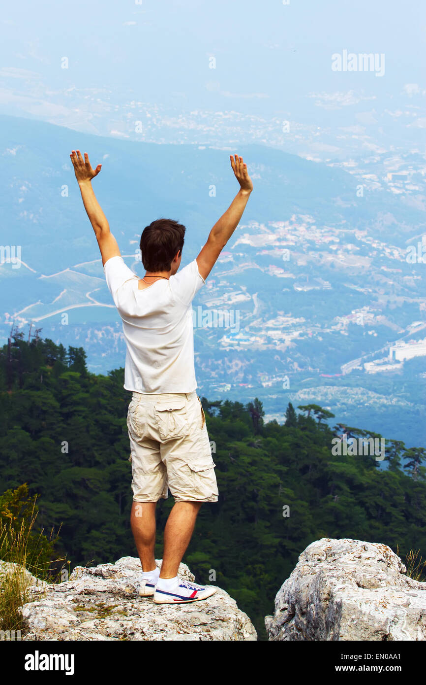 Young man standing on a cliff side Stock Photo