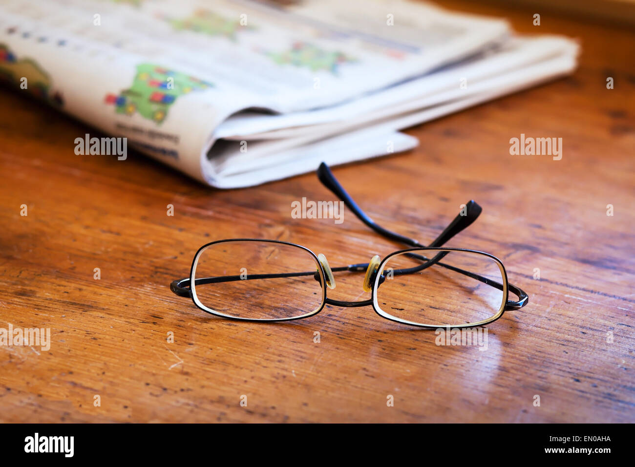 reading newspapers, close up of glasses on the wooden table Stock Photo