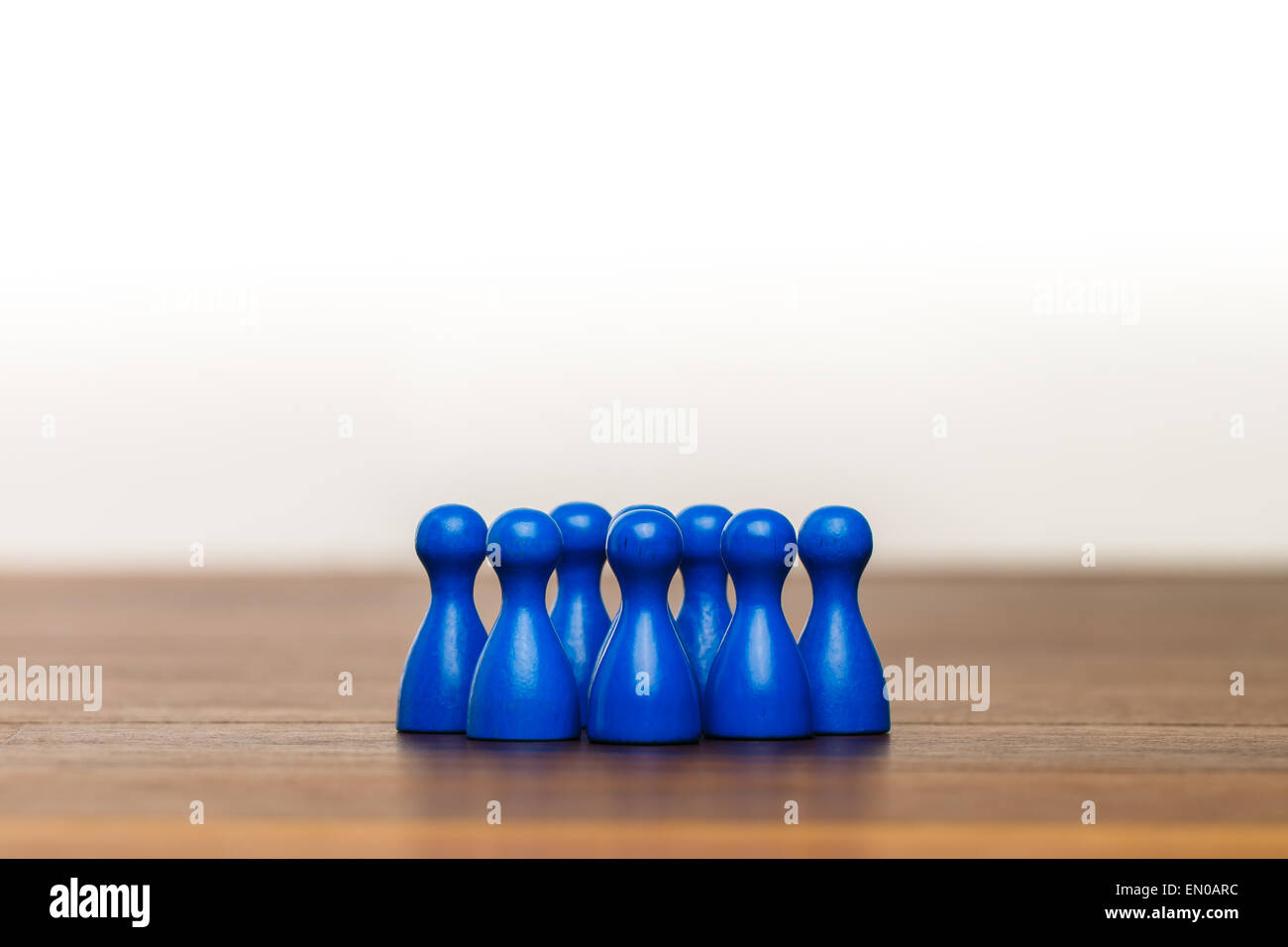 Concept for: team, group,  friends, working together. With blue pawn figures and white background on wooden surface. Stock Photo