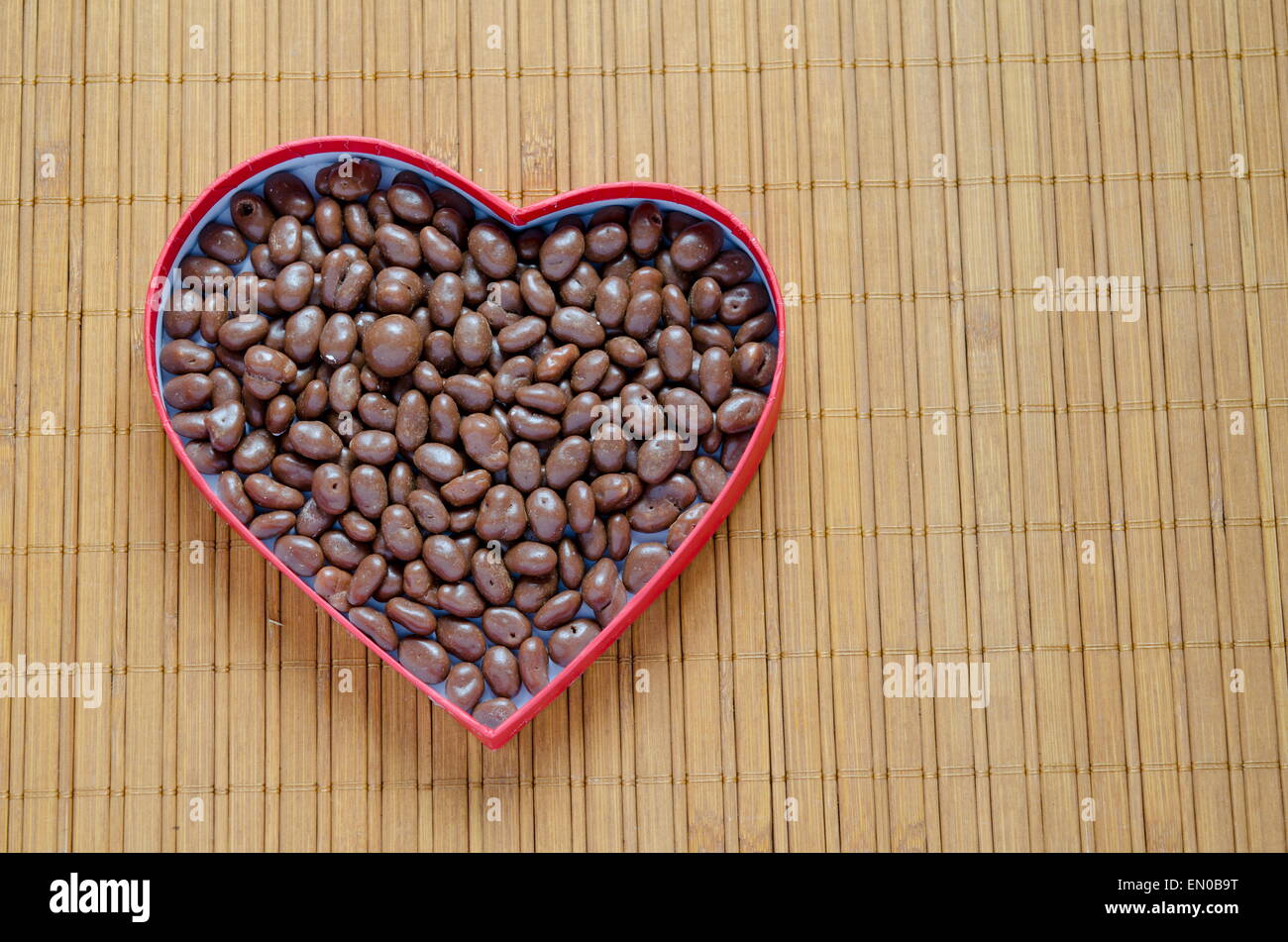 Heart Shaped Box Filled With Small Chocolates Balls On The Wooden