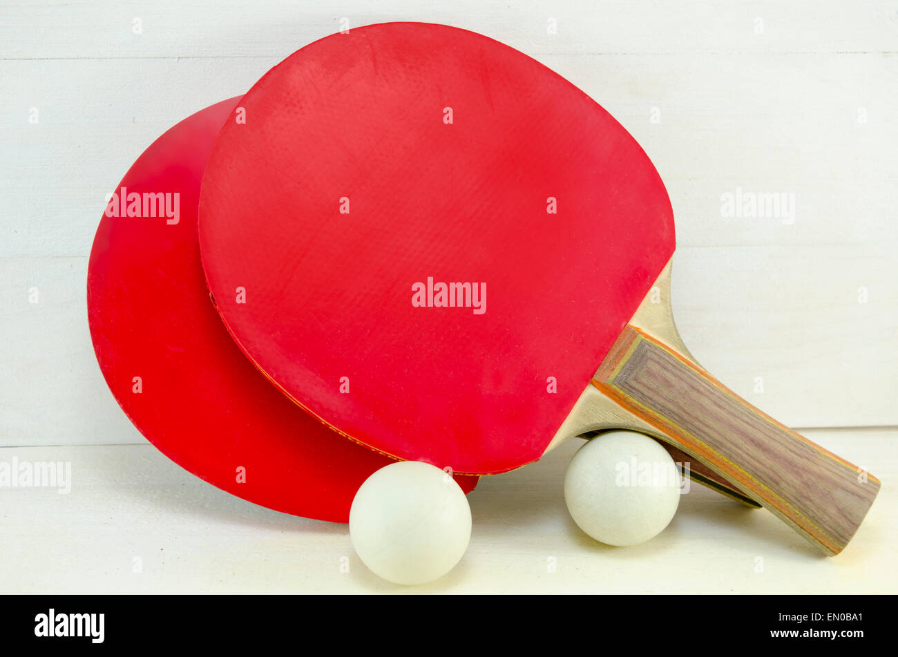 Two red table tennis rackets and balls on a wooden table Stock Photo