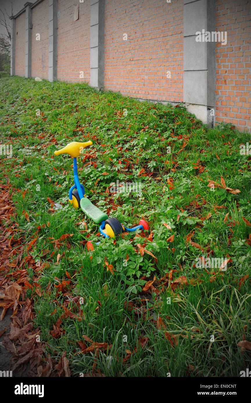 colorful scooter toy in the grass with vignette effect Stock Photo