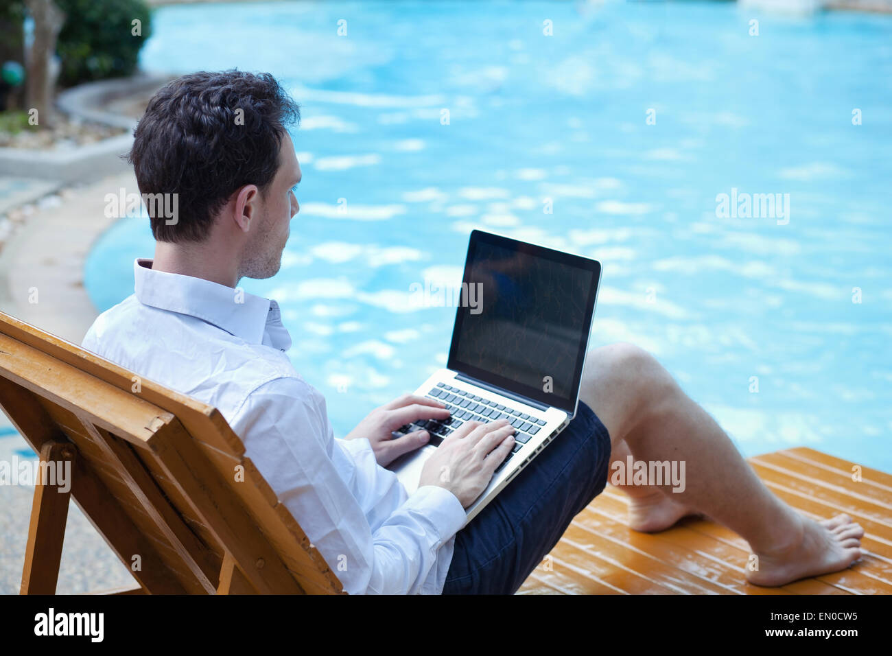 business man with laptop in luxury hotel near swimming pool Stock Photo