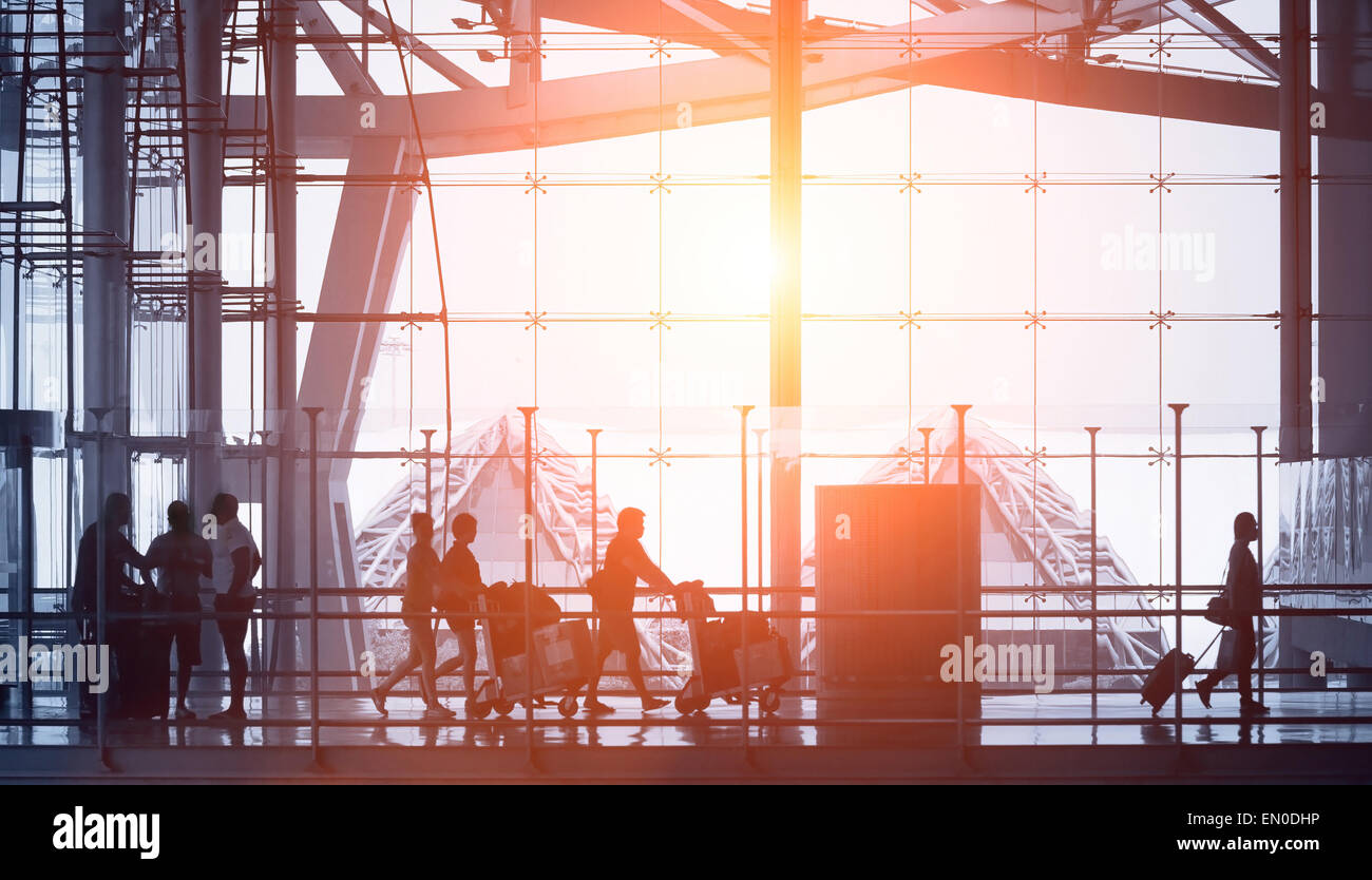 commuters walking in modern airport, back light Stock Photo