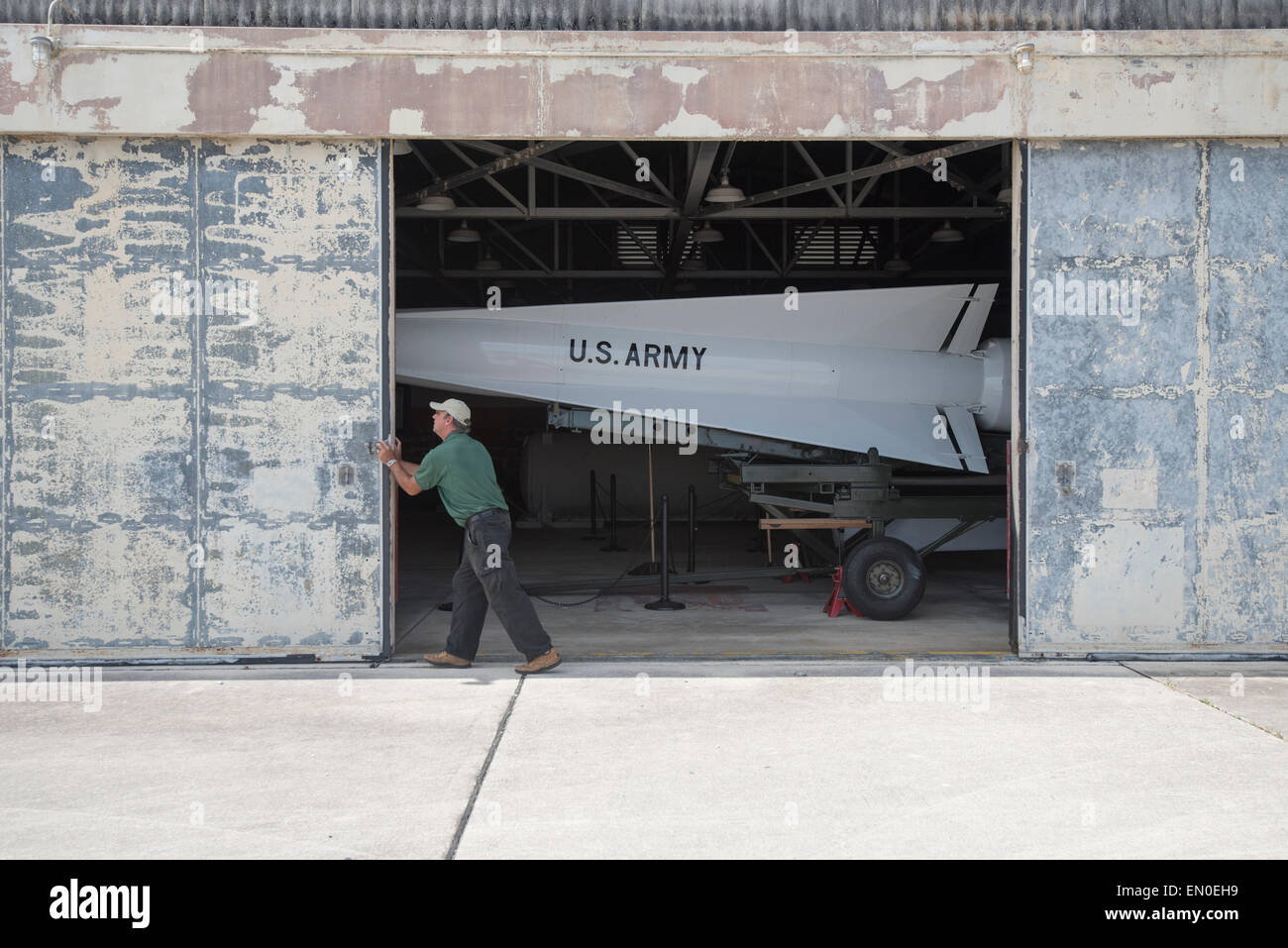 A park ranger slides open the doors of an old missile storage shed, revealing the Nike missile that once guarded the US Stock Photo