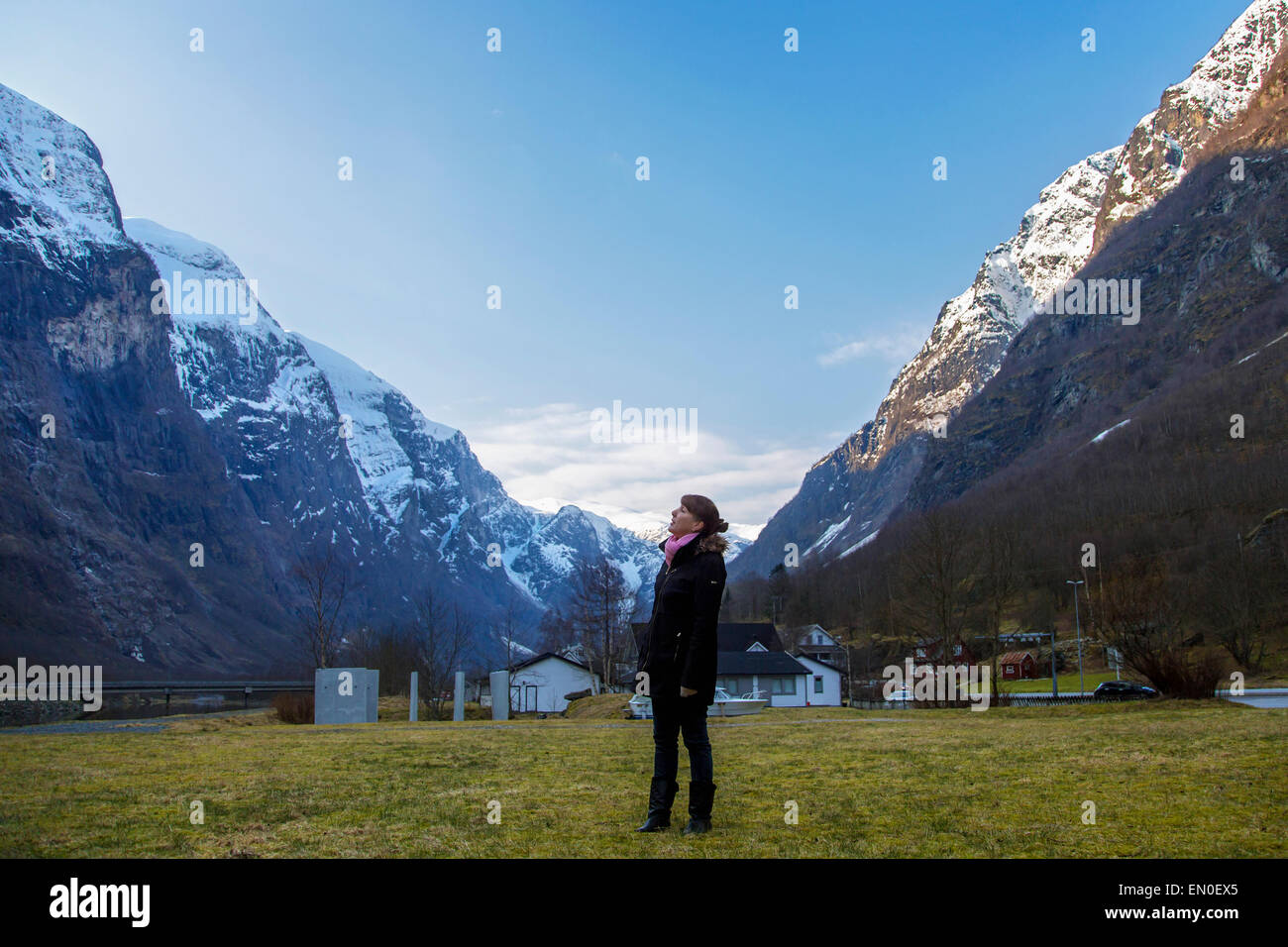 A woman standing and looking up at songfjord in Gudvangen,Norway Stock Photo