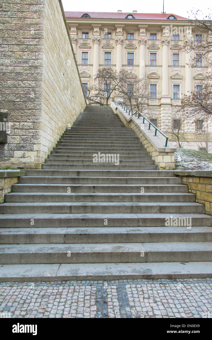 Concrete ladder from several flights fenced with a handrail and a wall