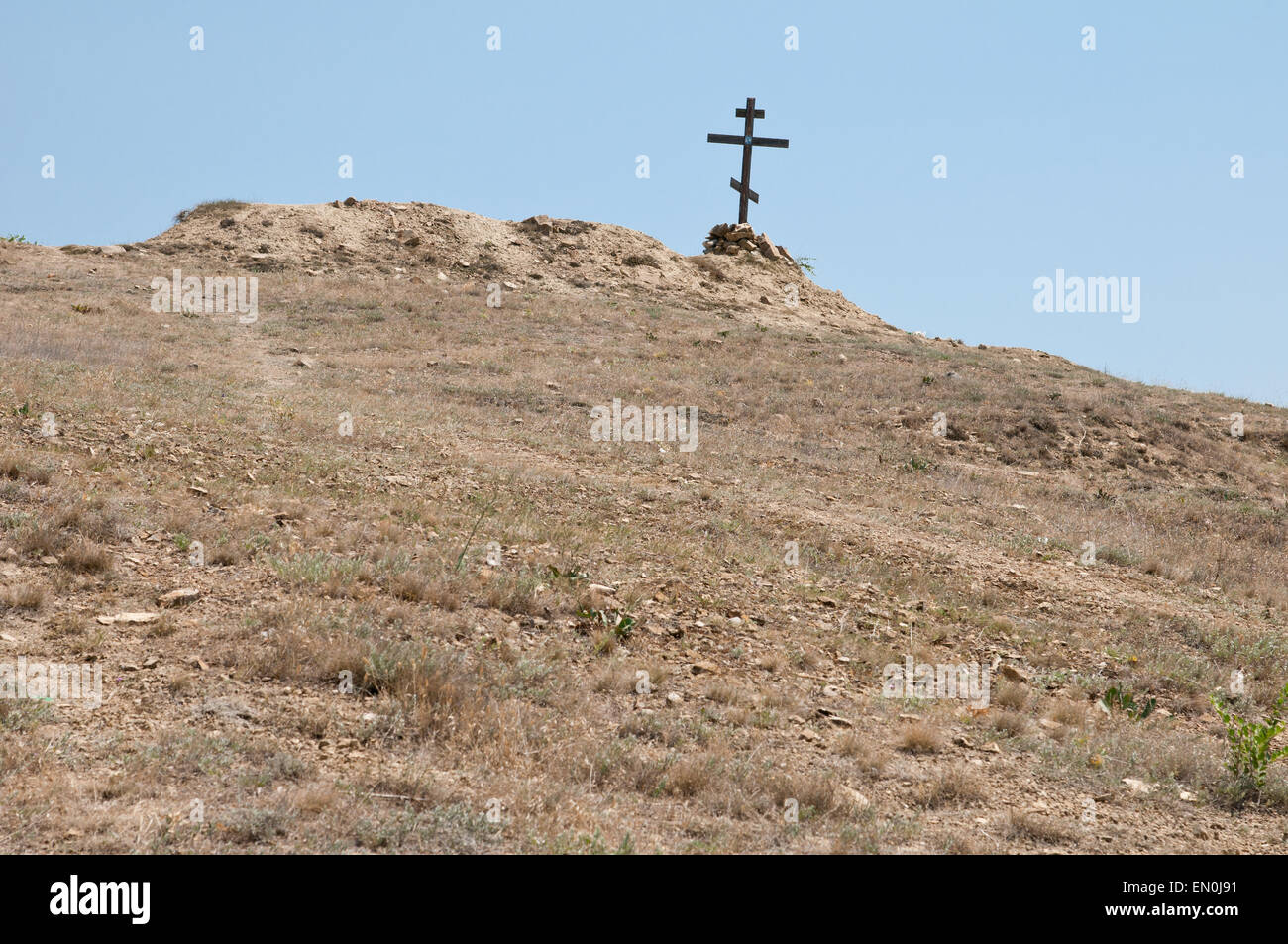 wooden cross on a lifeless dry hill Stock Photo