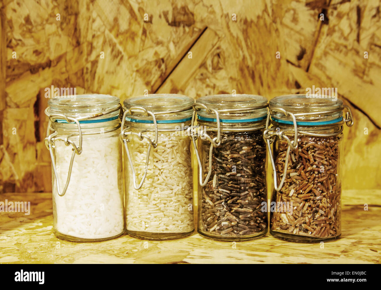 foure race of rice varieties in glass: brown rice, mixed wild rice,jasmine rice,rice burry on wood shelf Stock Photo