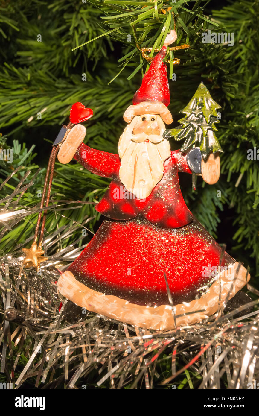 red Santa Claus shaped decoration on green Christmas tree Stock Photo ...