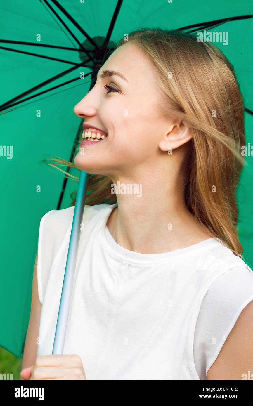 Happy smiling girl holding a green umbrella Stock Photo