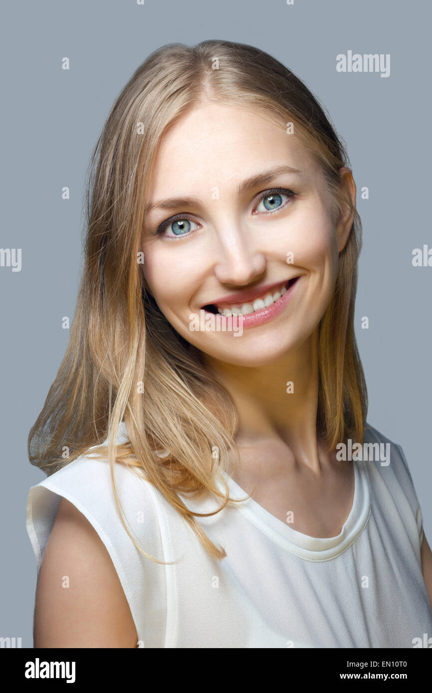 Portrait of a beautiful smiling young woman over gray background Stock ...