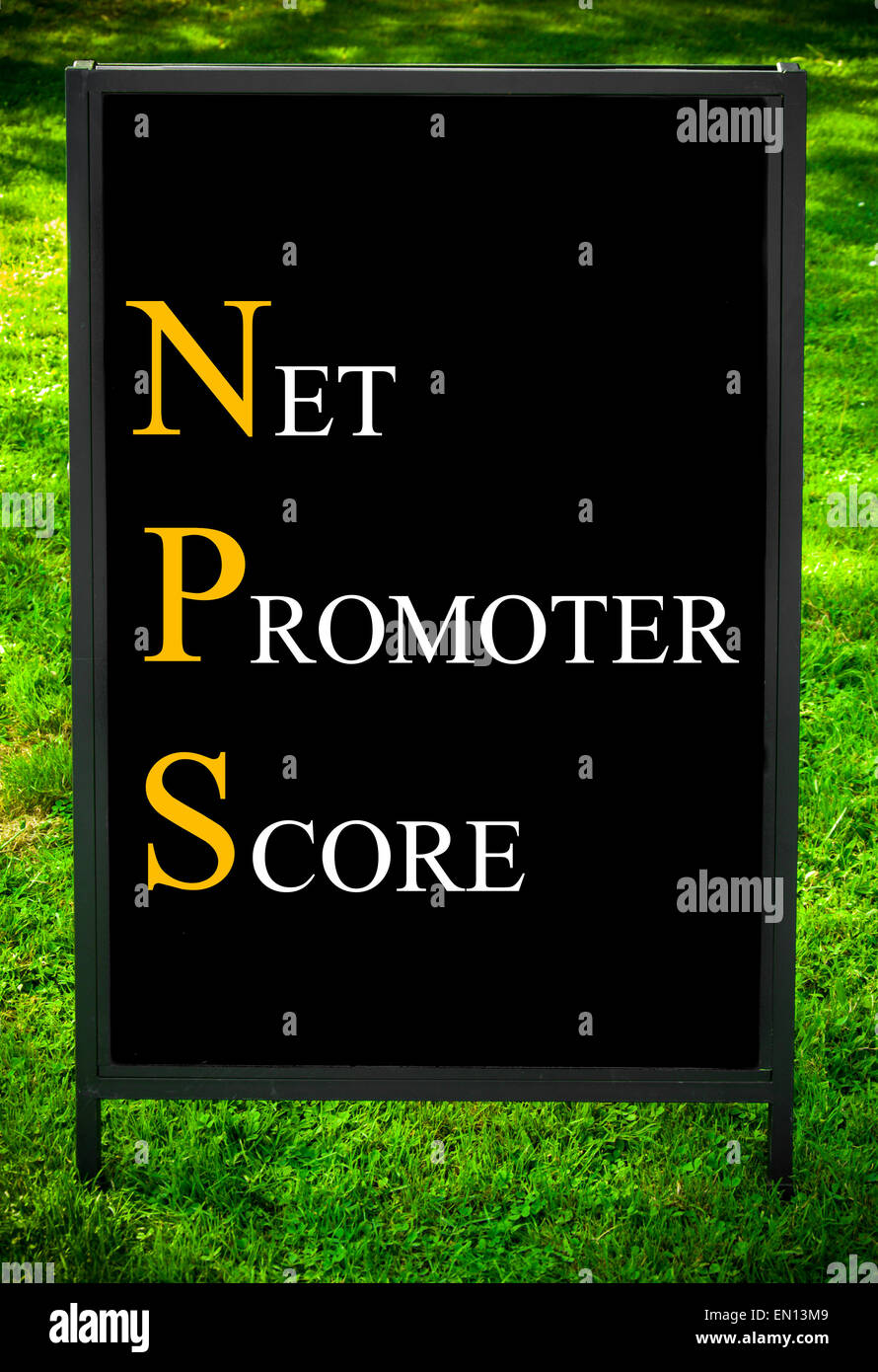 Business Acronym NPS as NET PROMOTER SCORE. Message on sidewalk blackboard sign against green grass background. Concept image Stock Photo