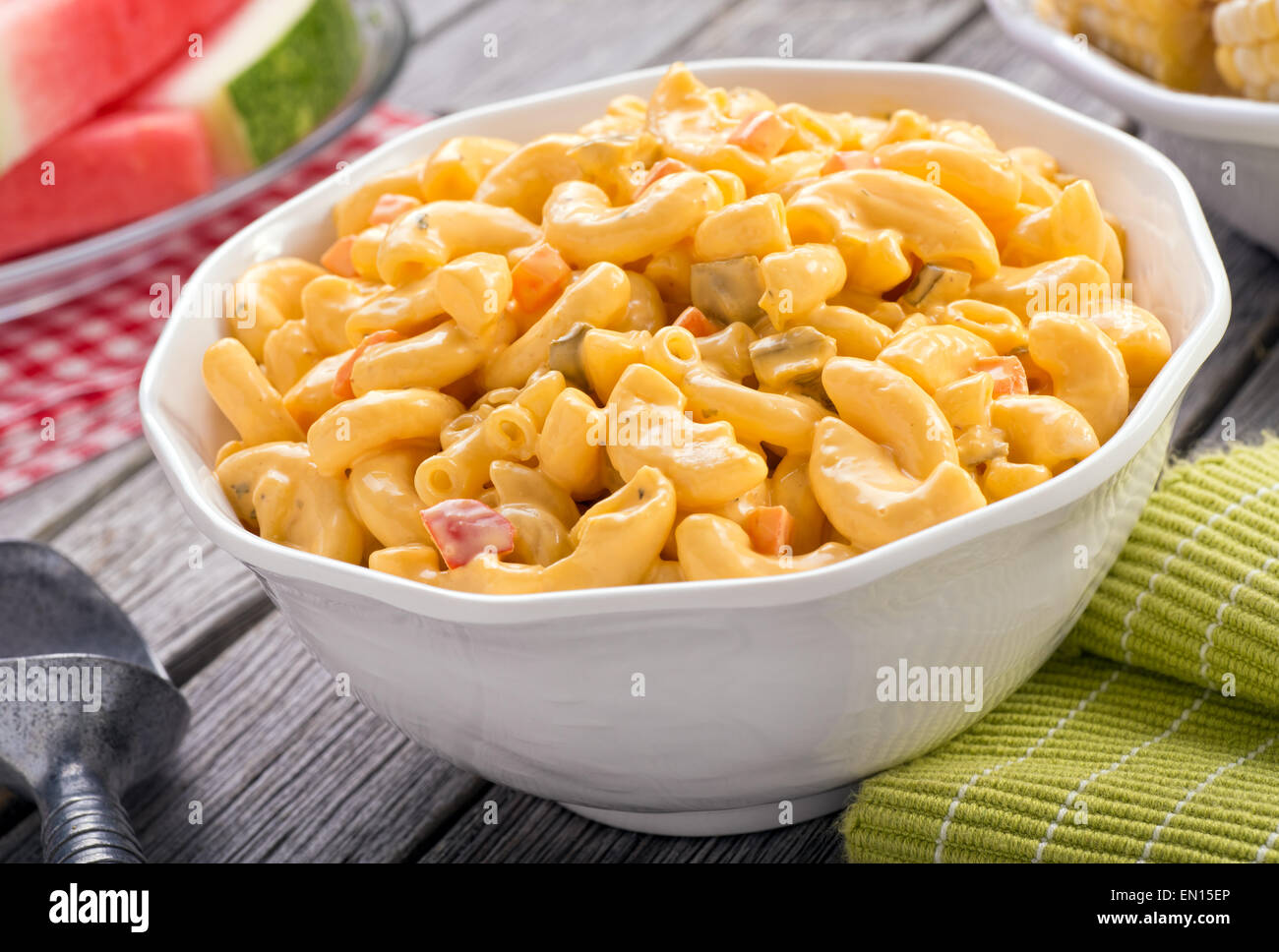 A bowl of delicious creamy macaroni and cheese salad on a rustic picnic