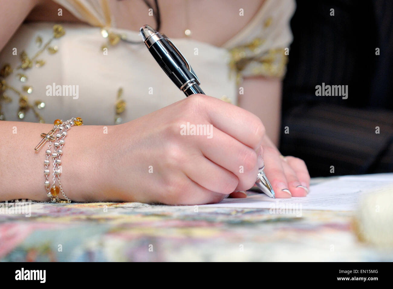 bride-signing-the-marriage-certificate-after-the-wedding-stock-photo