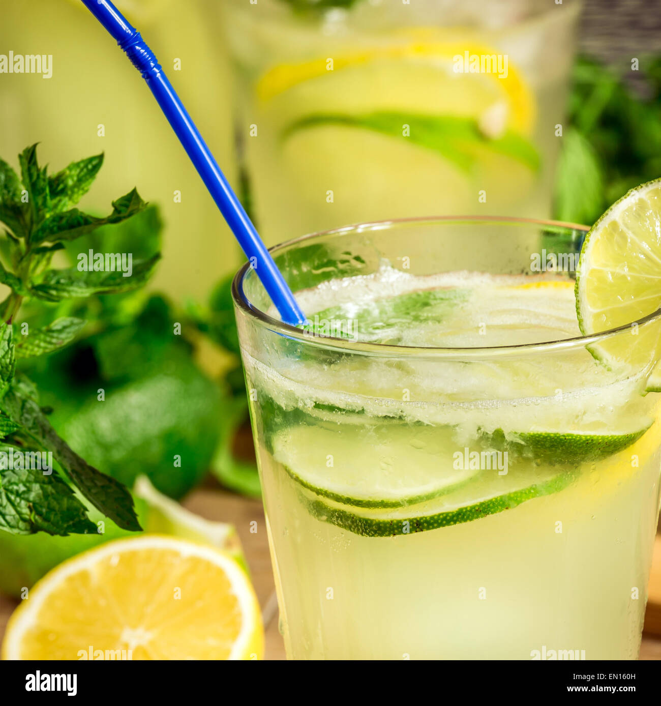 Refreshing lemonade drink and ripe fruits against wooden background Stock Photo