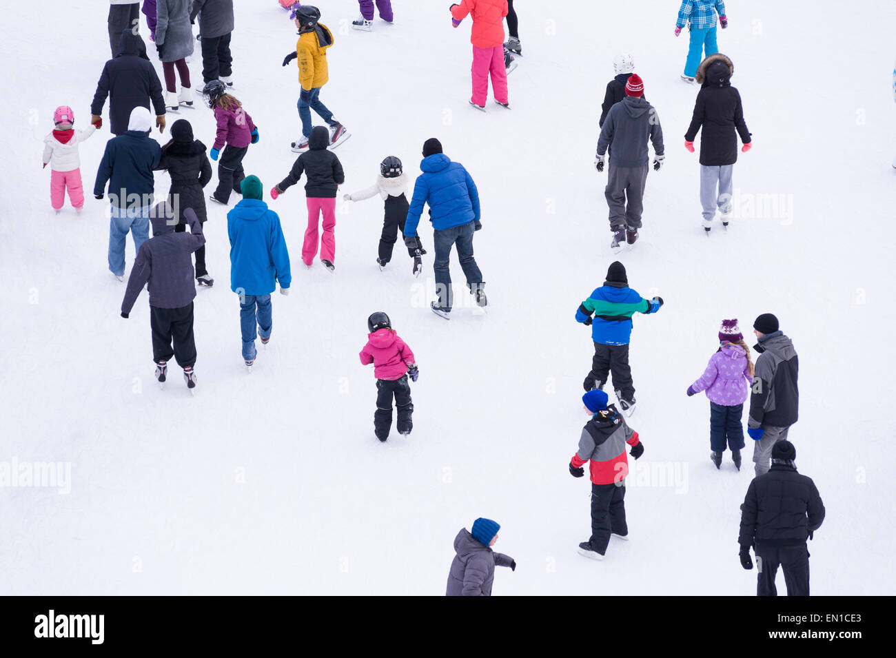 Aerial view of people skating in community rink during winter holiday ...