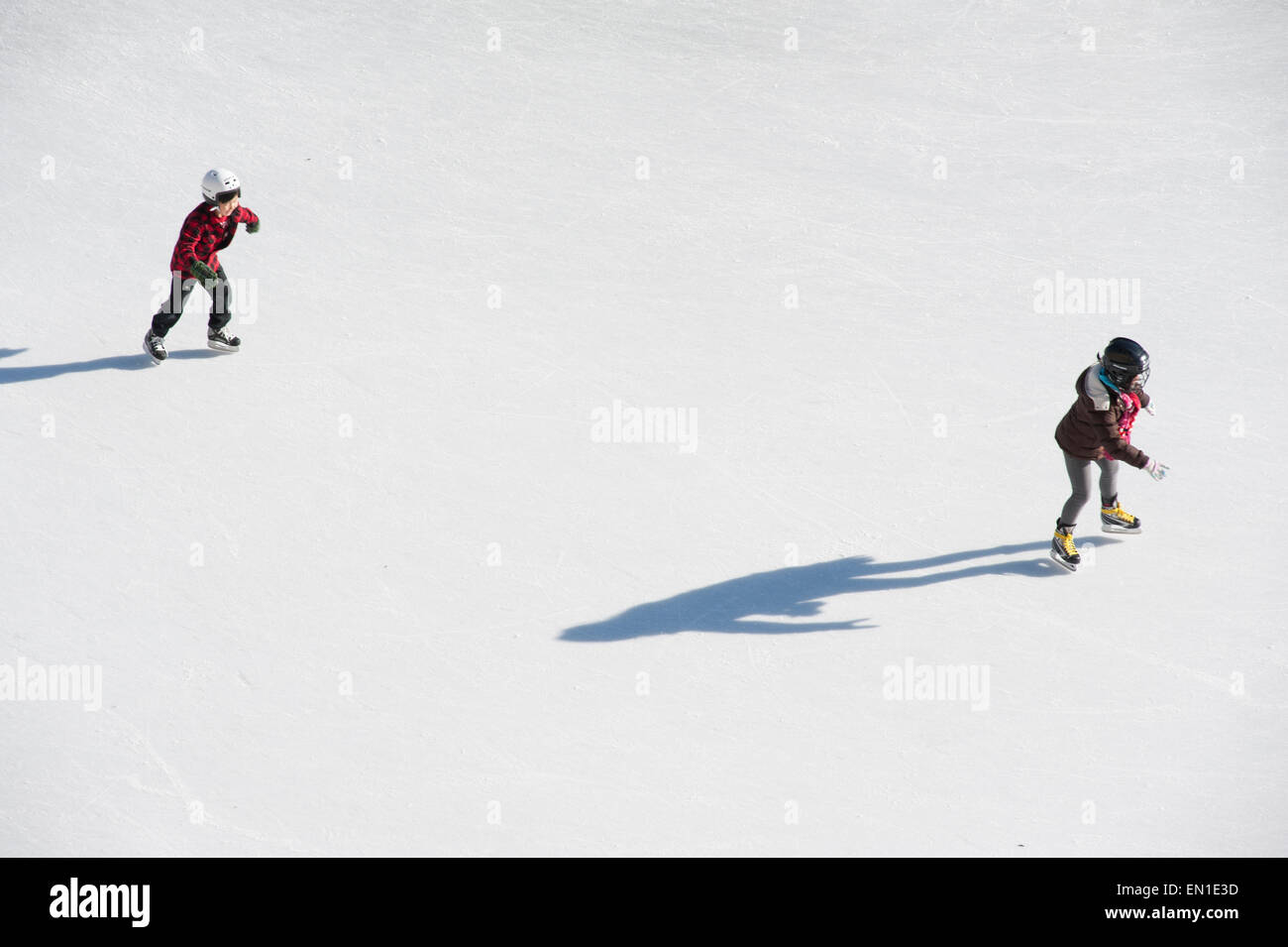 Aerial view of people skating in community rink during winter holiday ...