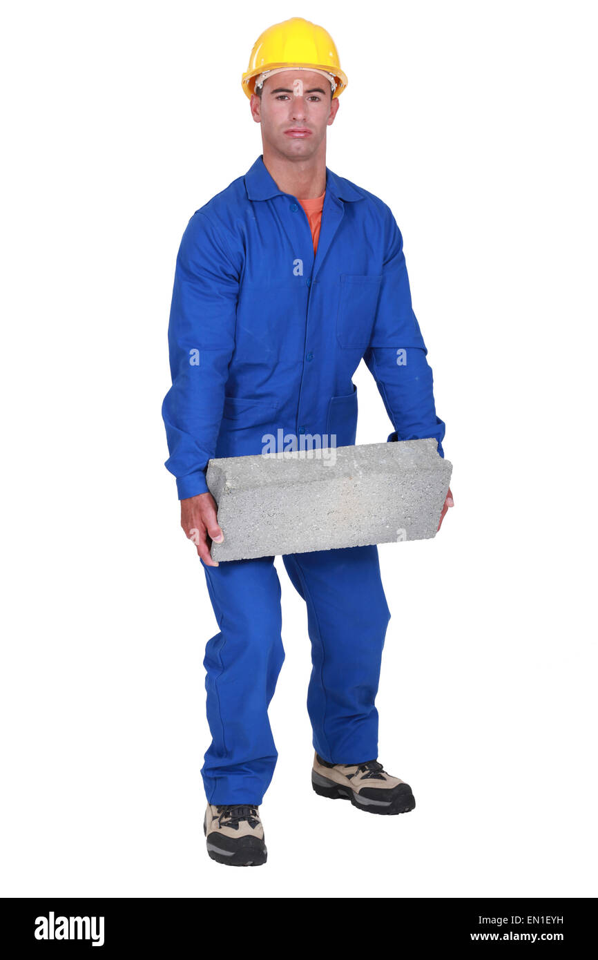 Labourer lifting a block Stock Photo Alamy