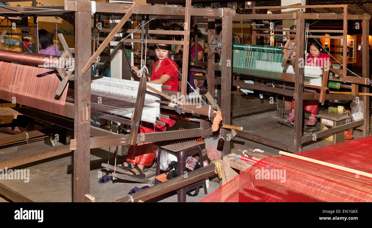 Silk workers, operating hand powered looms, Chiang Mai, Thailand Stock Photo