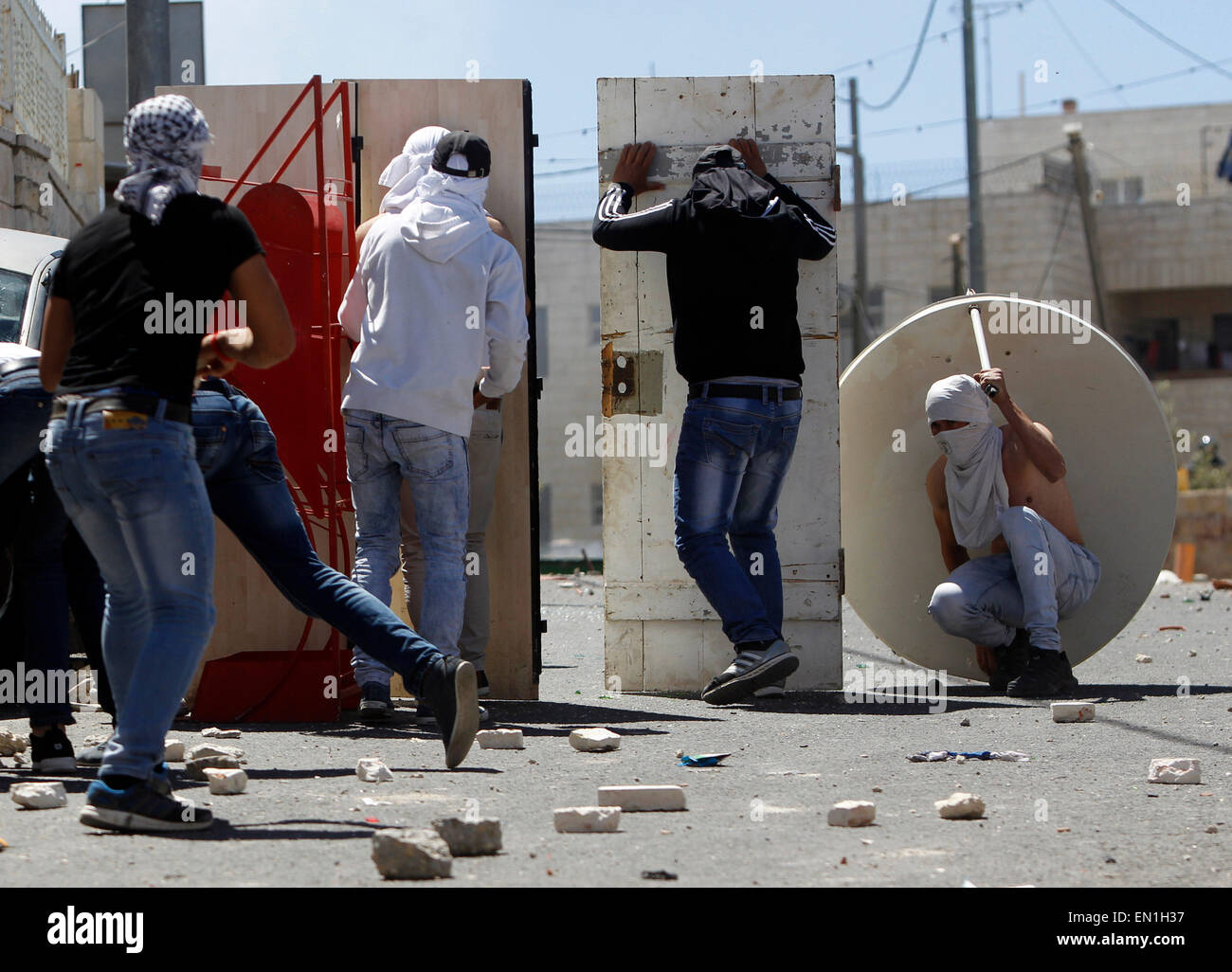 (150425) -- JERUSALEM, April 25, 2015 (Xinhua) -- Masked Palestinian youth take cover during clashes between Palestinians and Israeli security forces in Al-Tur neighbourhood of East Jerusalem, on April 25, 2015. Israeli paramilitary Border Police said Saturday that it shot dead a knife-wielding Palestinian youth near an east Jerusalem checkpoint after he attempted to attack them. Ali Said Abu Ghanam, a 16-year-old resident of the Palestinian neighborhood of At-Tur, started running toward the policemen at the A-Zayyim checkpoint Friday overnight, according to a police statement. (Xinhua/Muammar Stock Photo