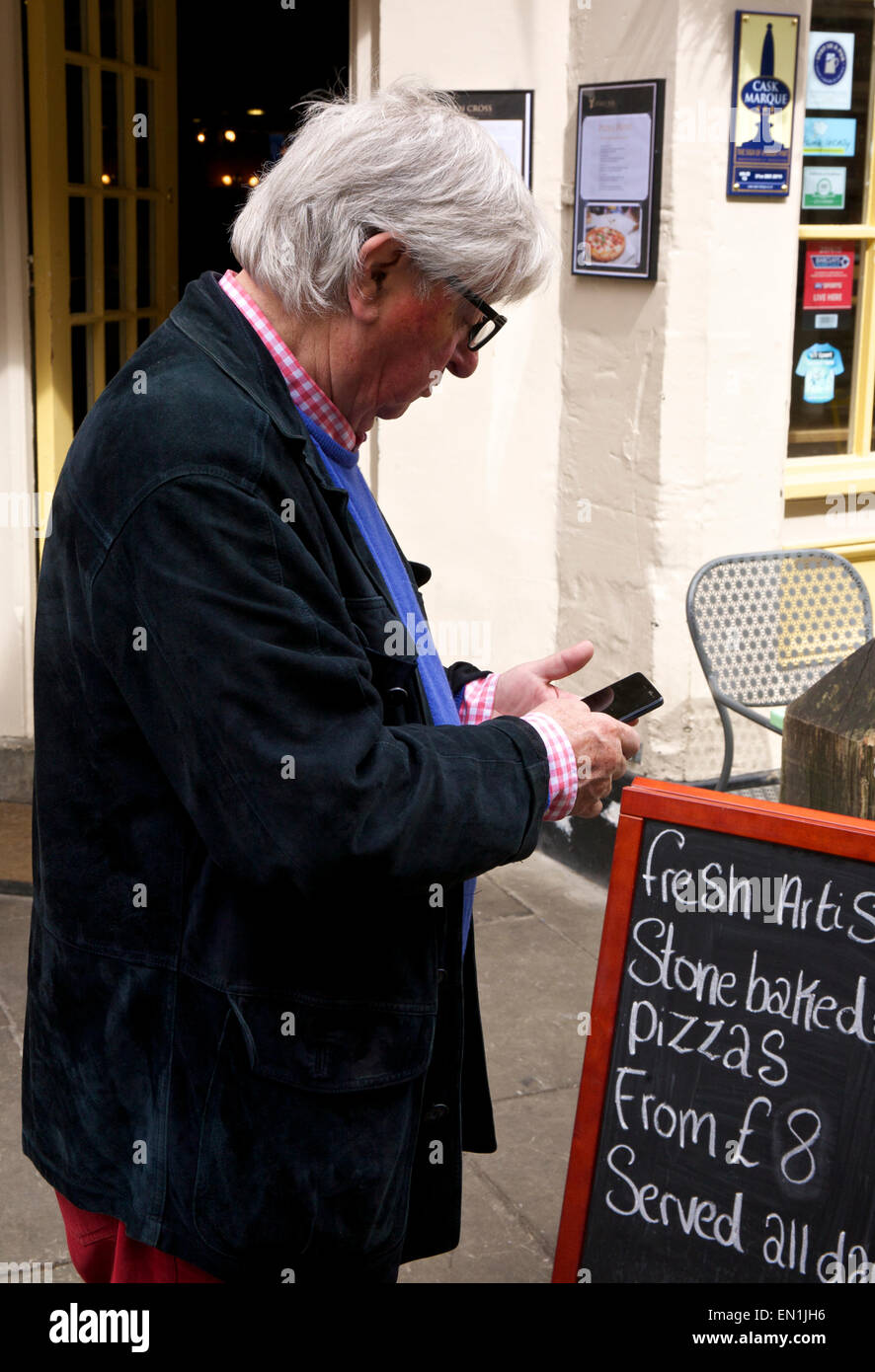 Mature Man Checking Email on Smartphone Cirencester Gloucestershire England UK Stock Photo