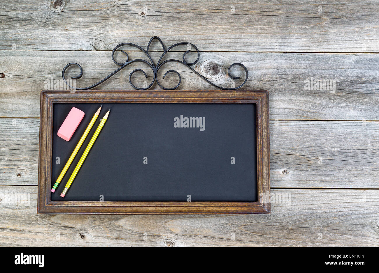 Old fashion chalkboard, pencils and eraser on rustic wood. Layout in
