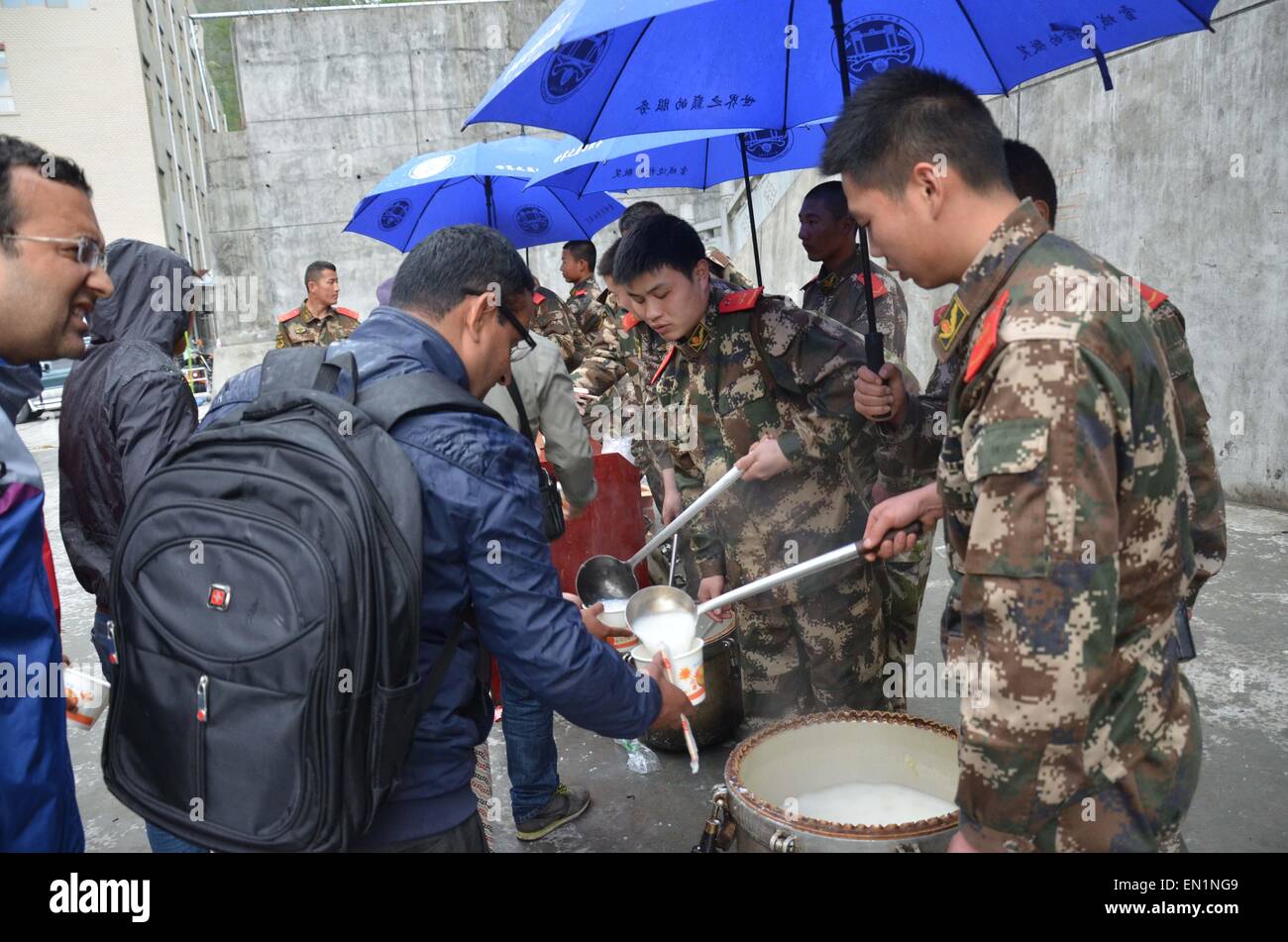 Xigaze. 25th Apr, 2015. Soldiers of the local public security frontier corps give tourists free porridge at a checkpoint of Zhangmu Township in Nyalam County, April 25, 2015. More than 500 tourists stranded by a powerful earthquake in Nepal have been properly relocated at the Zhangmu checkpoint. © Meng Taizong/Xinhua/Alamy Live News Stock Photo